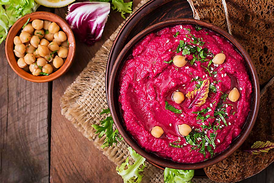 Roasted Beet Hummus with toast in a ceramic bowl