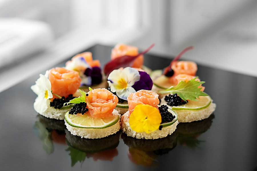 Delicious appetizer with salmon and edible flowers.