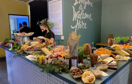 a waiter is serving grazing table in a office