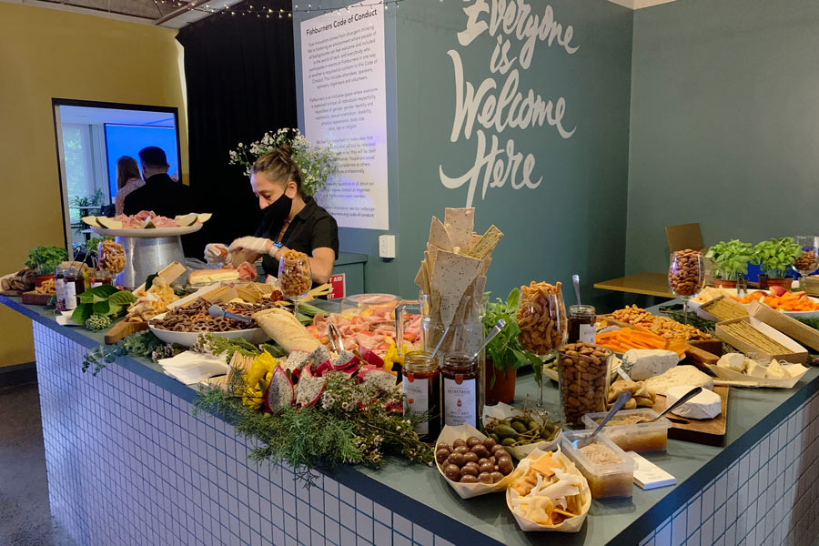 a waiter is serving grazing table in a office