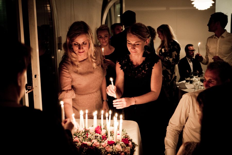 2 ladies putting candles on a birthday cake at a birthday party