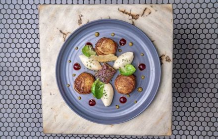 Chef Daragh Matheson Pan seared scallops, cauliflower puree, braised pork belly, brussel sprout leaf, caper raisin sauce, cranberry gel