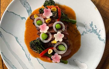 Chef David Makeri Grilled Sirloin, Citrus Cola Jus, Roasted Sweet Peppers, Sauteed Brocollini, Shallots, Roasted Corn