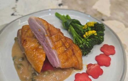 Chef Oliver King Orange Glazed Duck Breast with Caper Veloute Sauce, Steamed Broccolini wrapped with Green Onion, and Cucumber Flowers Infused with Beet Juice